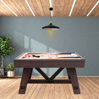 Wooden pool table in a room with wooden flooring and gray walls.