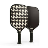 Two pickleball paddles, one with a houndstooth pattern and the other black, on a white background.