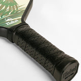 Close-up of a pickleball paddle with a black grip and visible brand name on a light gray background.