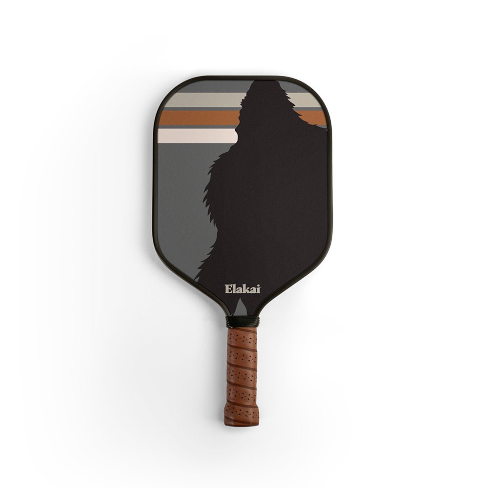 Pickleball paddle with a black face and brown handle on a white background