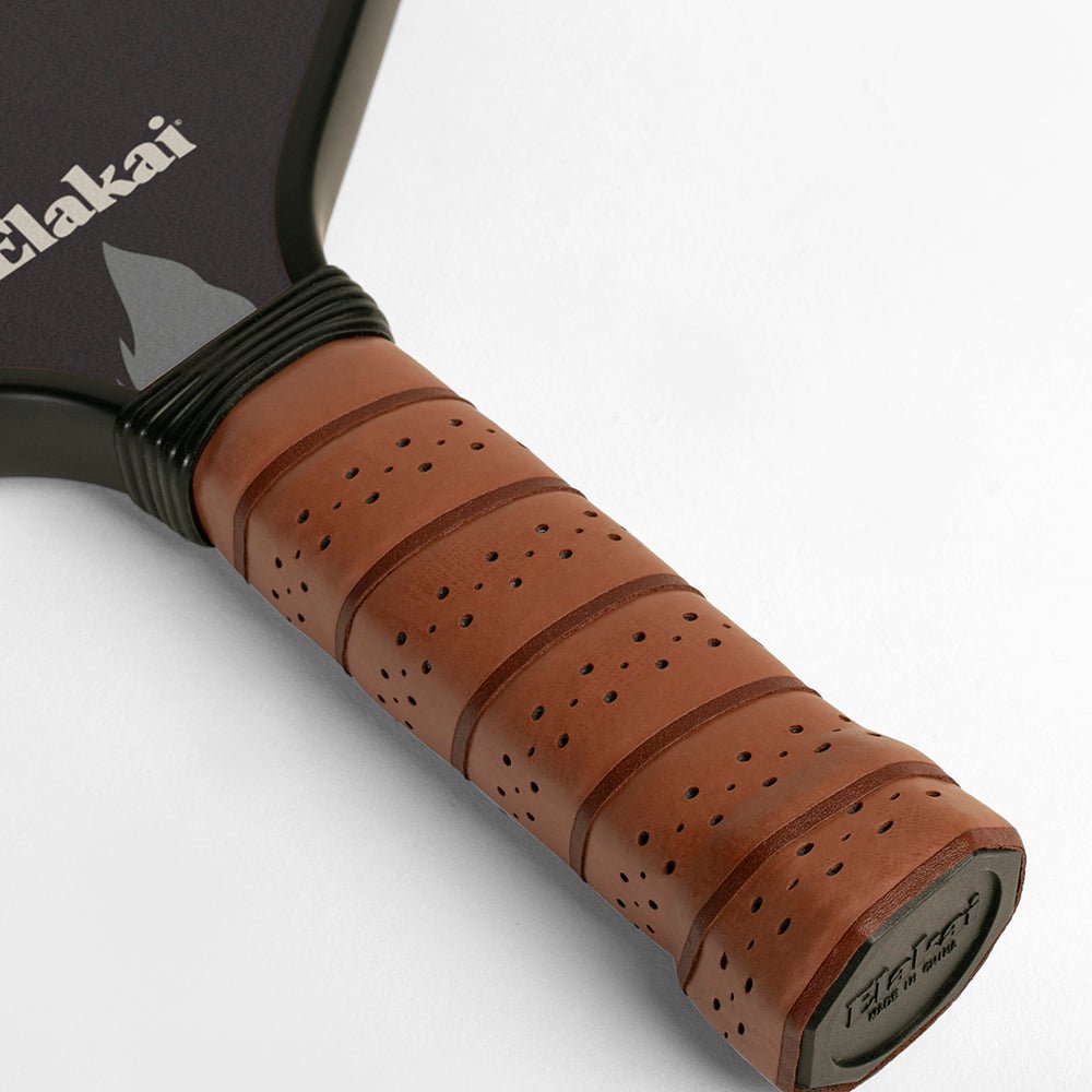 Close-up of a brown tennis racket handle with 'Eakai' branding on a white background