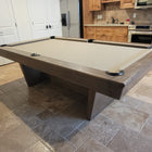 Nixon KAI 8' Slate Pool Table by Nixon Billiards in walnut, shown in tiled room with cabinets.