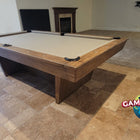 Nixon Billiards KAI 8' Slate Pool Table in walnut finish, shown in a tiled room with fireplace.