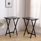 Two black folding tables with logos on a wooden floor.