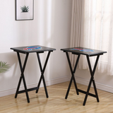 Two black folding tables with logos on a wooden floor.