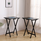 Two black folding tables with blue coasters on a wooden floor.