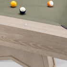 Close-up of a wooden pool table showing the light oak frame, green felt surface, and several billiard balls on a white background.