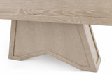 Close-up of a light oak wood table showing the underside of the tabletop and a geometric, angular pedestal base on a white background.