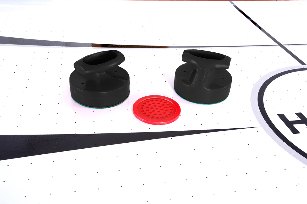 Two black strikers and a red puck on the Hathaway Brentwood 7.5-Ft Air Hockey Table.