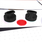 Two black strikers and a red puck on the Hathaway Brentwood 7.5-Ft Air Hockey Table.