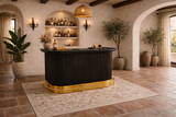 Luxury bar setup with dark wood counter and gold base in a stylish room.