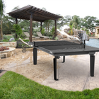 Outdoor ping pong table in a backyard setting with a pool and patio.
