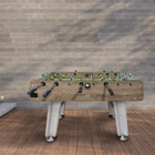 Foosball table outdoors against a wooden wall