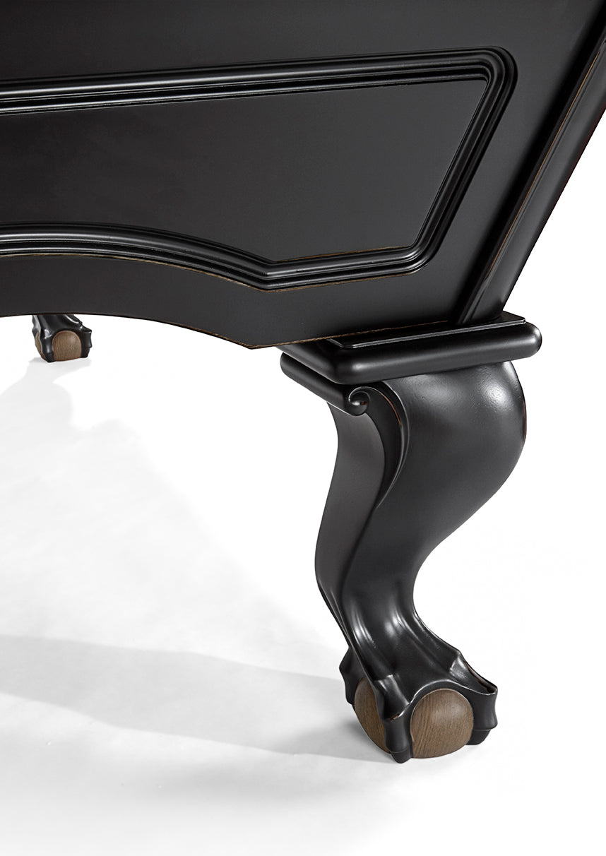 Close-up of Brunswick Billiards Glenwood 7’ Matt Black pool table’s curved wood leg on white.