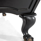 Close-up of Brunswick Billiards Glenwood 7’ Matt Black pool table’s curved wood leg on white.