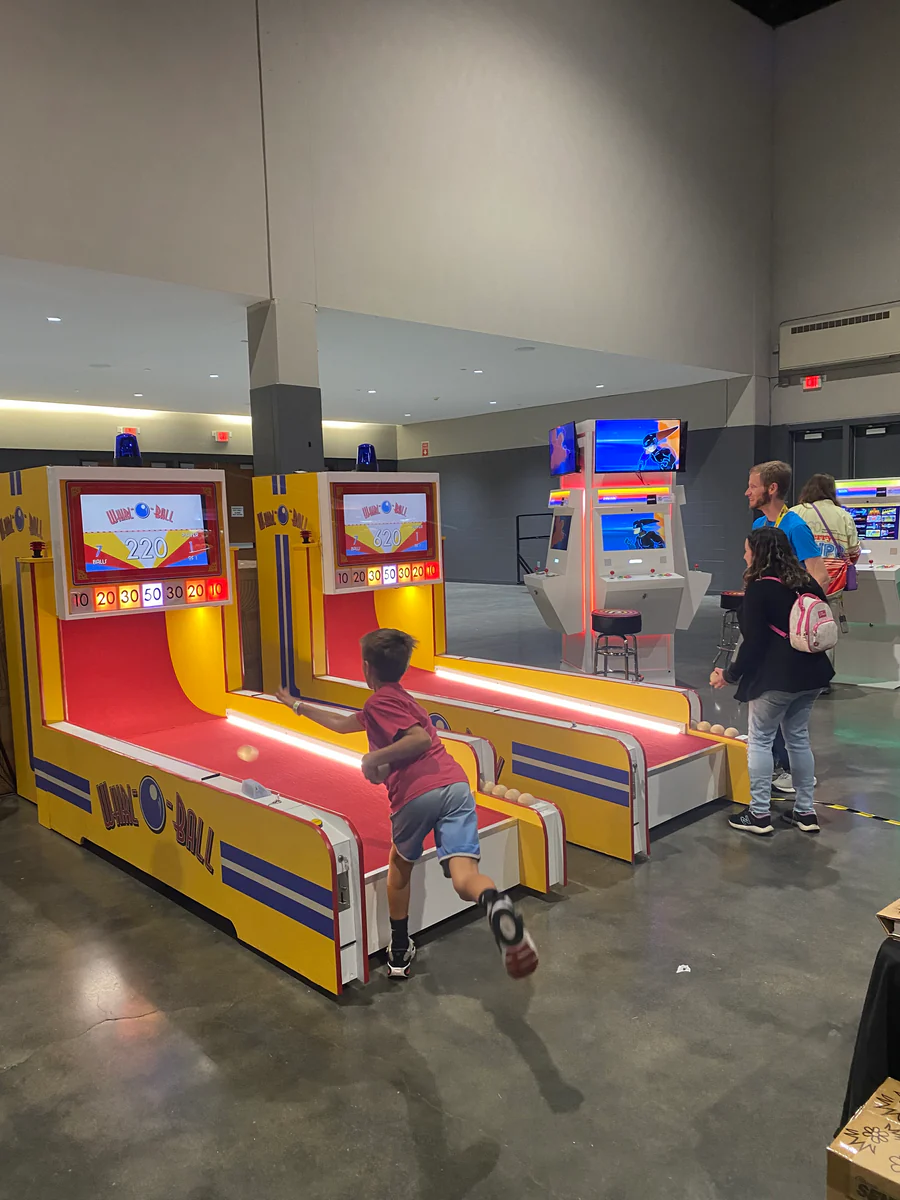 Children playing at an arcade with colorful game machines.
