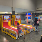 Children playing at an arcade with colorful game machines.