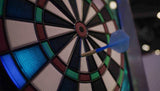 Dart hitting a target with colorful sections on a dark background