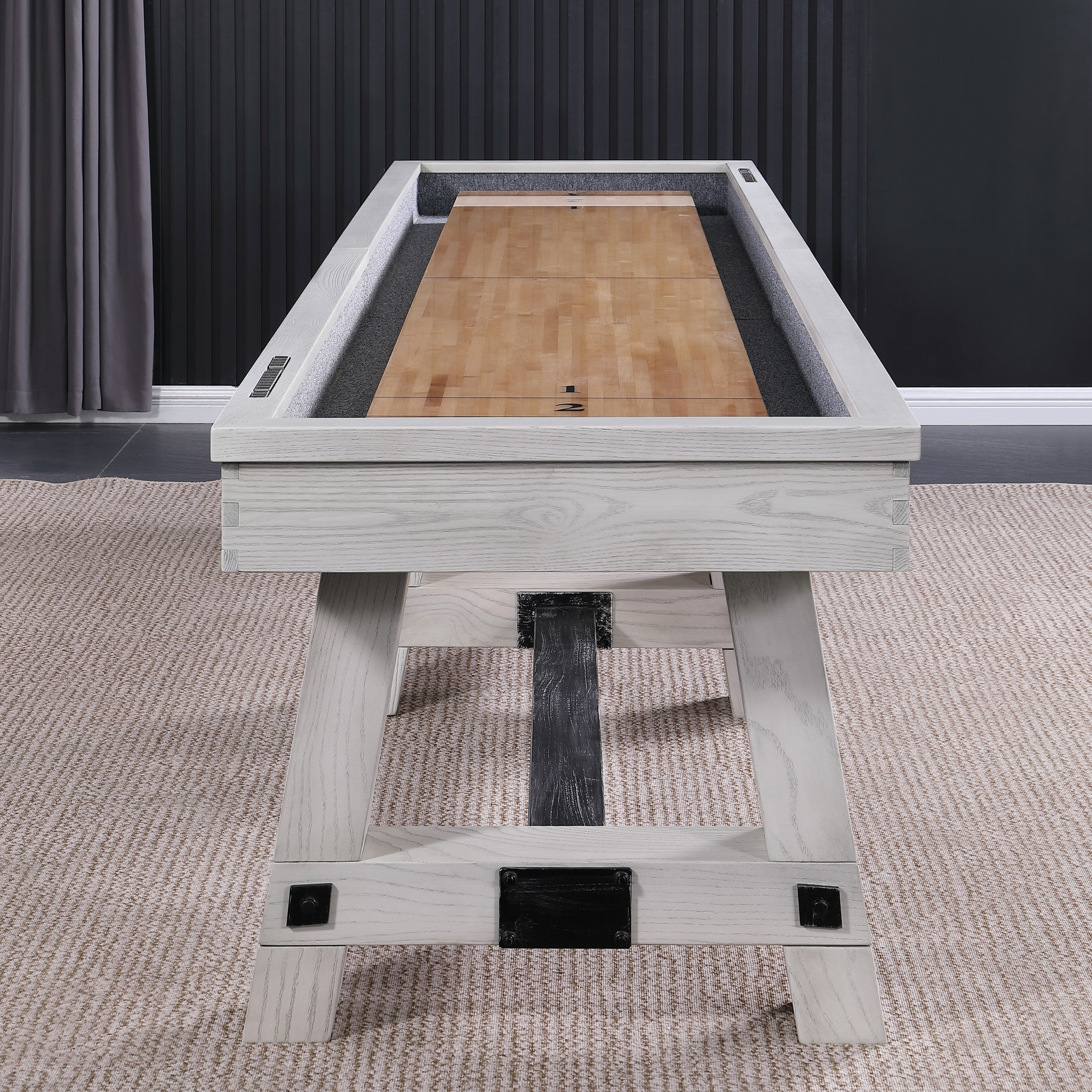 Playcraft 16' Yukon Pro-Style Shuffleboard Table in Northern Drift on carpet, dark wall behind.