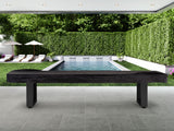 American Heritage Lanai 12' Outdoor Shuffleboard Table in Obsidian Black with pool and chairs.