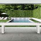 American Heritage Lanai 12' Pearl White Shuffleboard Table on a patio by the pool and garden.