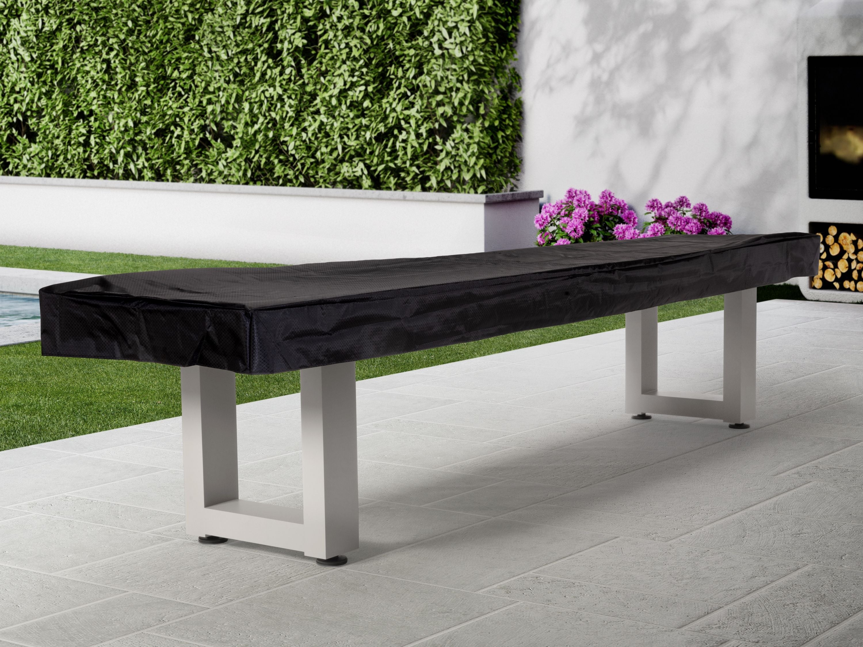 American Heritage Lanai 9' Outdoor Shuffleboard Table in Pearl White on patio near flowers.