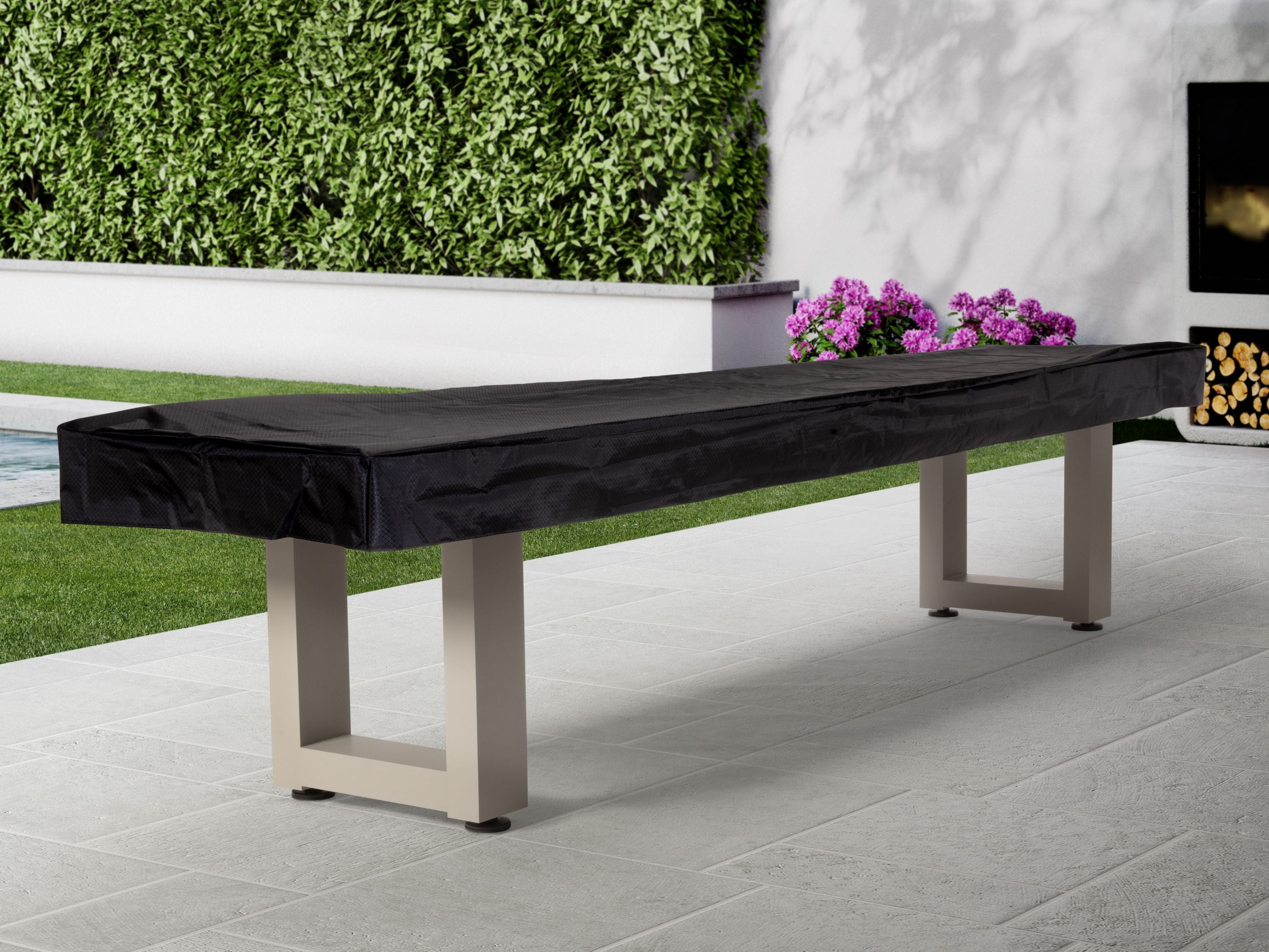American Heritage Lanai 12' Outdoor Shuffleboard Table in Oyster Grey on patio near garden.