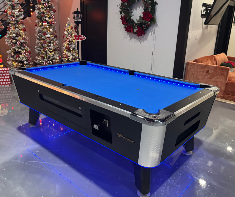Pool table with blue felt surface in a room decorated for Christmas.
