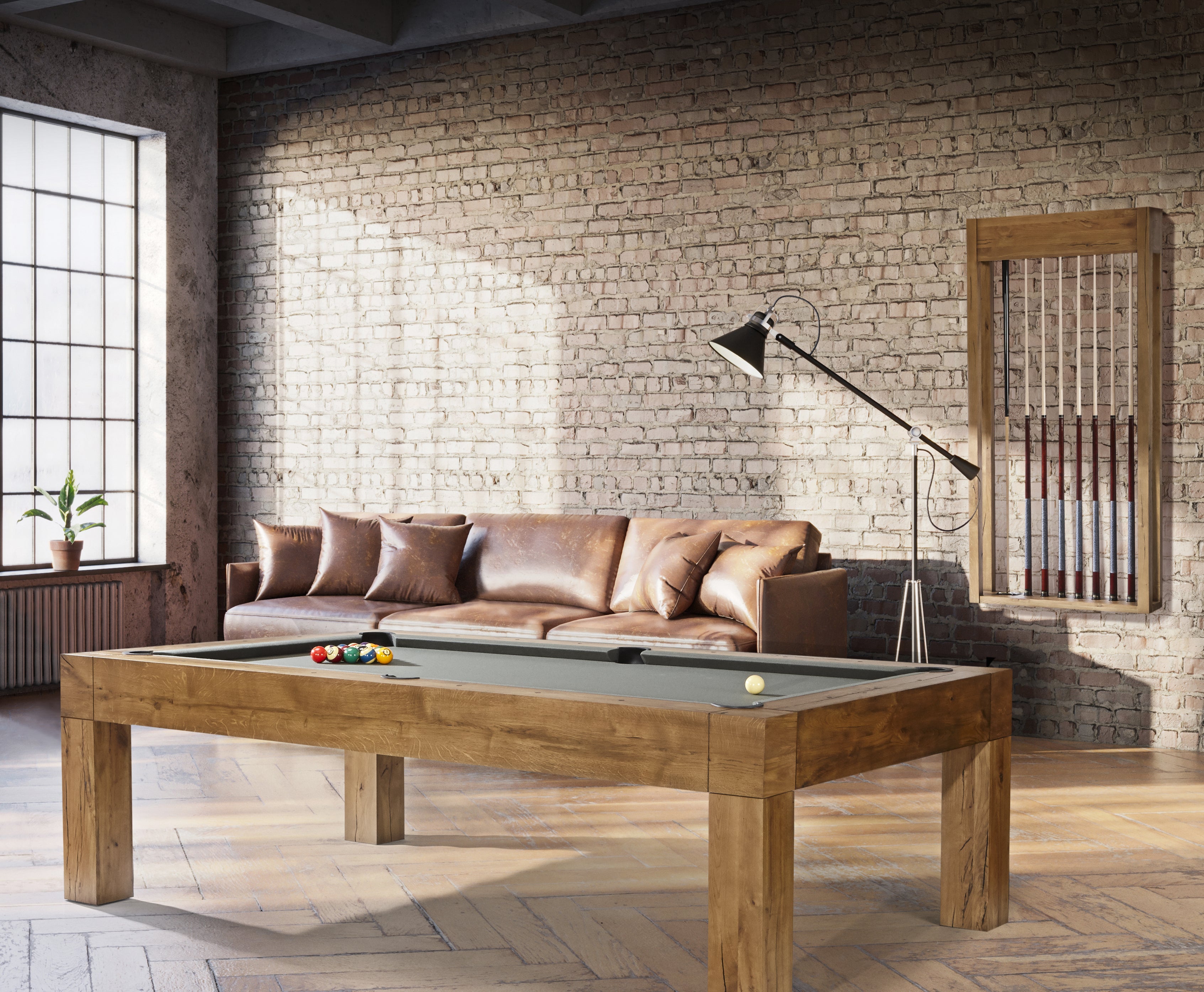 A modern living room with a Brunswick Billiards Parsons 8' Pool Table, leather sofa, and brick walls.