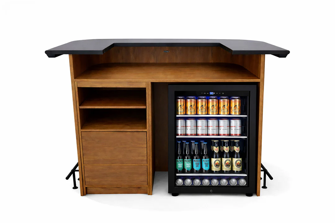 Wooden bar counter with black top and built-in cooler filled with drinks on a white background