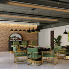Modern restaurant with green chairs, gold accents, and a black RAM Game Room poker table by the brick wall.