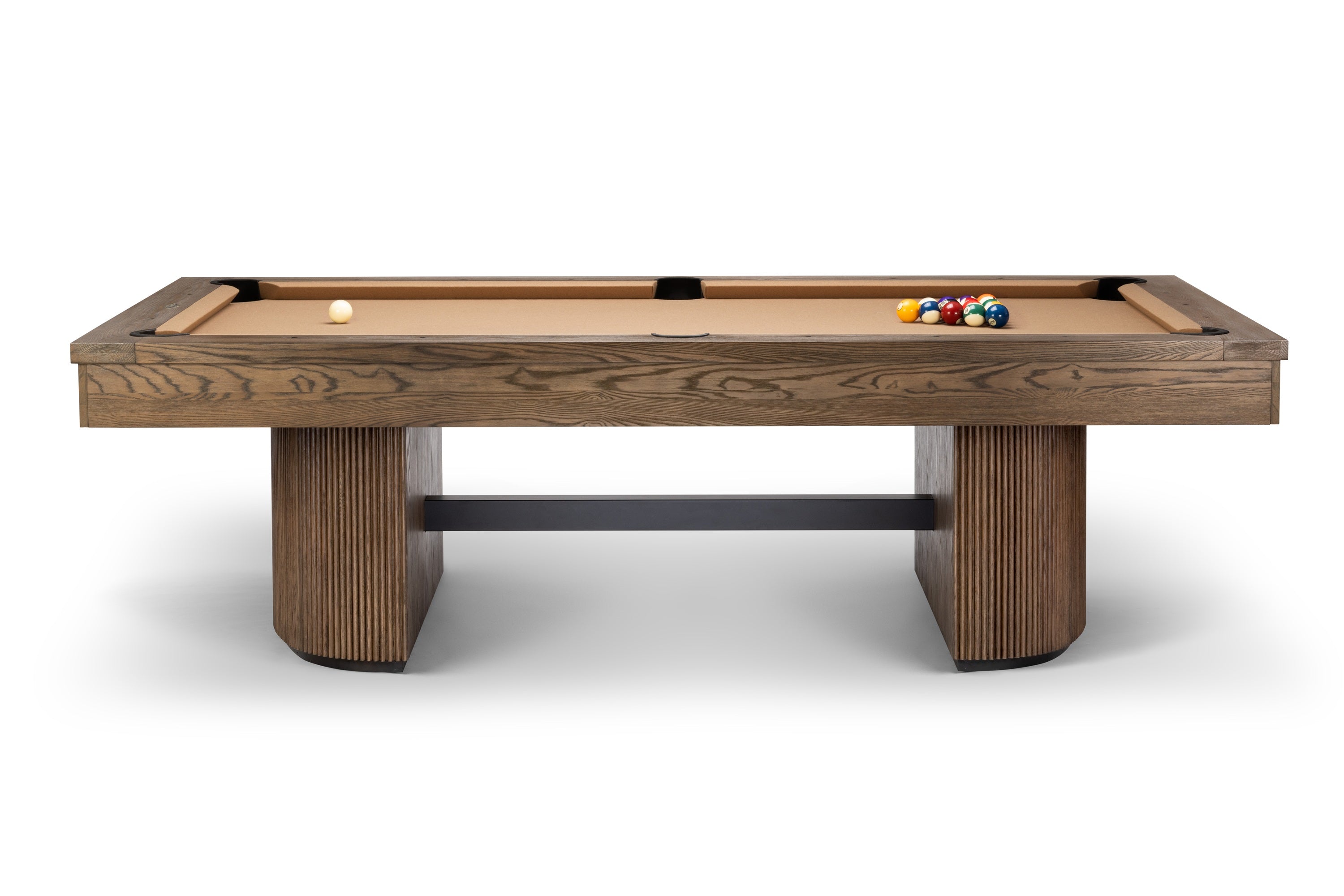 A modern pool table with a medium brown wood grain frame and legs, featuring a tan felt playing surface, a white cue ball, and a rack of colorful billiard balls, shown against a plain white background.
