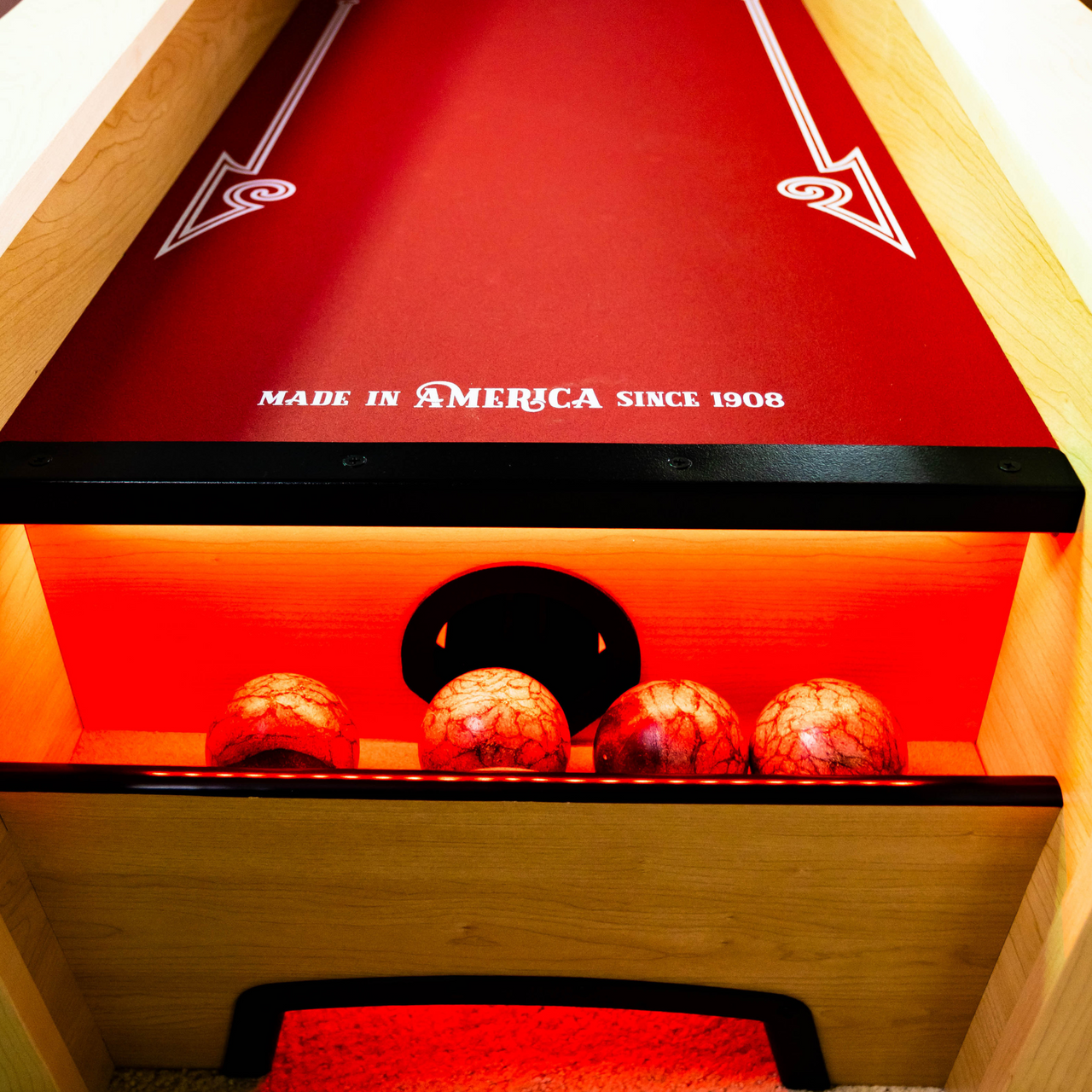 Close-up of a red bowling alley with wooden sides and 'Made in America since 1906' text.