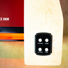 Close-up of a control panel with buttons labeled 'Volume', 'Game', 'Players', and 'Start' on a wooden surface.