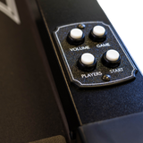 Control panel with buttons labeled 'Volume', 'Game', 'Players', and 'Start' on a black surface.