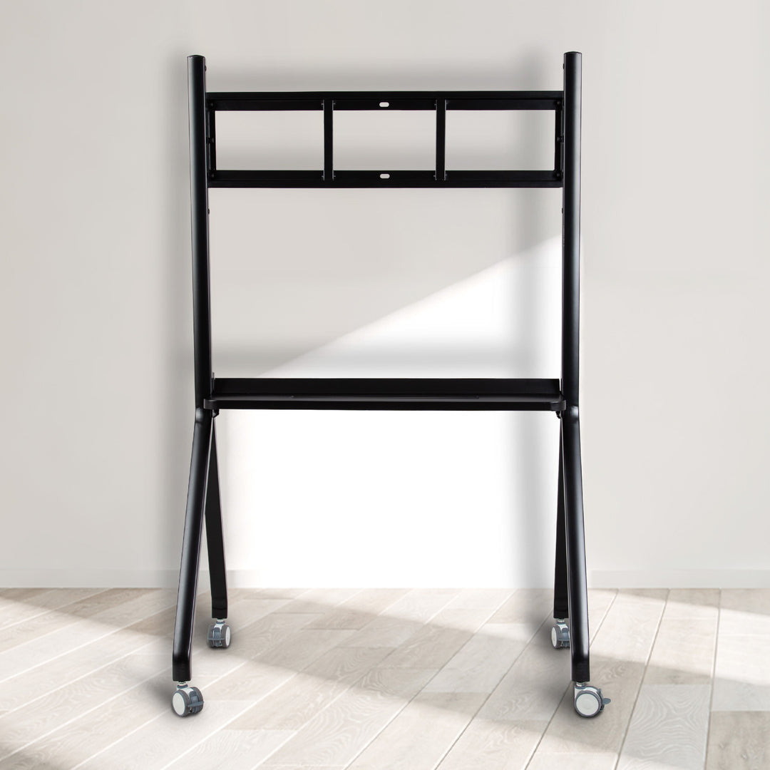 Black metal ladder with wheels on a light wooden floor against a white wall