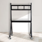 Black metal ladder with wheels on a light wooden floor against a white wall