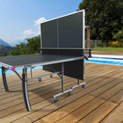 Outdoor ping pong table on a wooden deck with a pool and scenic background