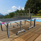 Butterfly outdoor ping pong table on a wooden deck with a pool and scenic background