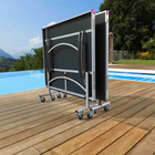 Foldable outdoor table on wheels by a pool with scenic background