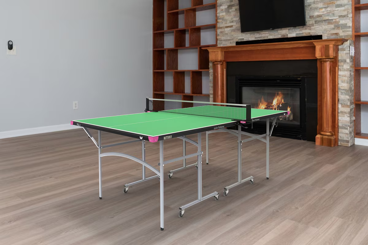A vibrant Butterfly Junior Rollaway Table Tennis Table in green indoor in room