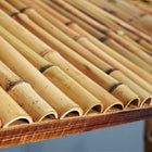 Close-up of the RAM Game Room 60" Bamboo Tiki Bar's bamboo roof above an outdoor lounge area.