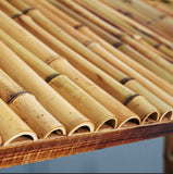 Close-up of the RAM Game Room 60" Bamboo Tiki Bar's bamboo roof above an outdoor lounge area.