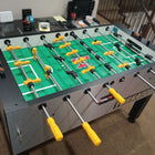 Tornado T-3000 Silver foosball table with yellow and black handles in a carpeted room.