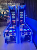 Two Valley Jet-Pong machines by Valley glow blue in a game room.