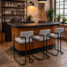 Bar area with wooden counter and stools in a brick-walled room.