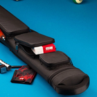 A black pool cue case on a blue pool table, shown with a wooden cue shaft tucked into one of its zippered compartments. A red and white box, a small black accessory, and a red-and-black card are placed beside the case.