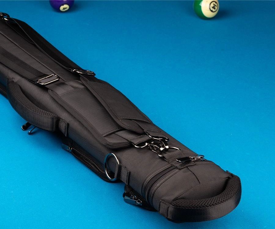 A black multi-pocket billiards cue case with silver buckles and a metal ring, shown on a bright blue pool table with pool balls in the background.