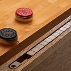 Two pucks on a Brunswick Billiards Botanic 12' Shuffleboard Table in Rustic Dark Brown.