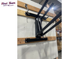 Wooden shelf with metal brackets against a white wall in a warehouse setting.